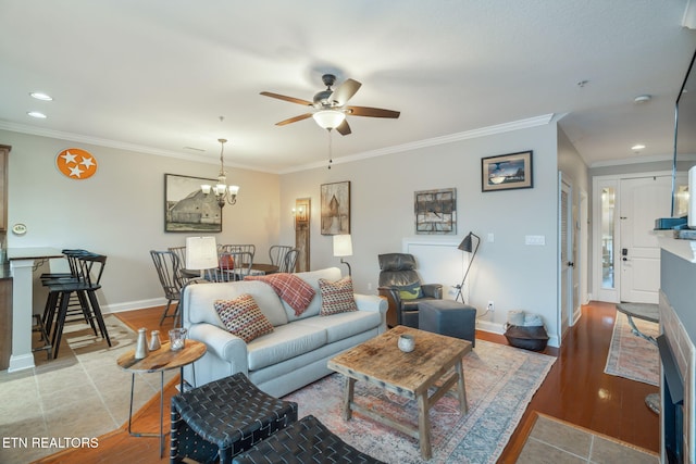 living room with ceiling fan with notable chandelier and ornamental molding