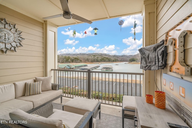 balcony featuring ceiling fan, a water view, and an outdoor hangout area