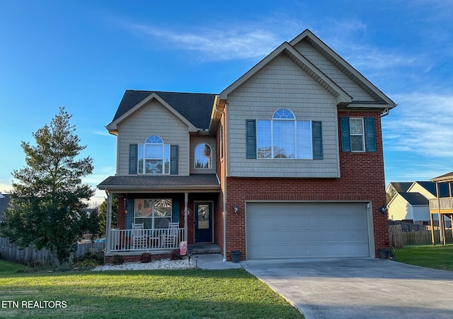 traditional-style home with brick siding, driveway, a front lawn, covered porch, and an attached garage