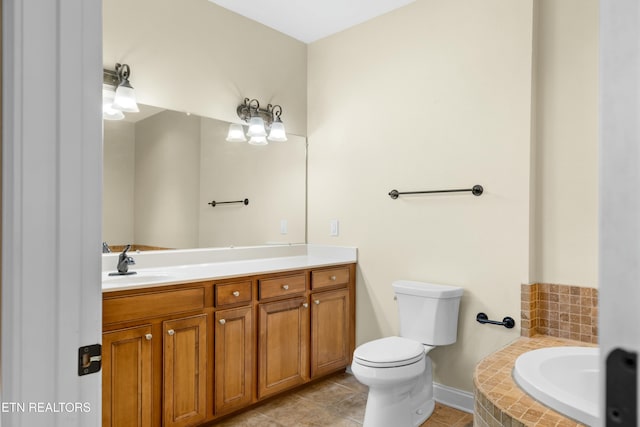 bathroom with tile patterned floors, vanity, toilet, and a tub to relax in