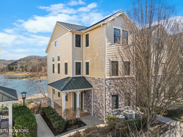 view of side of home featuring a water view and central AC unit