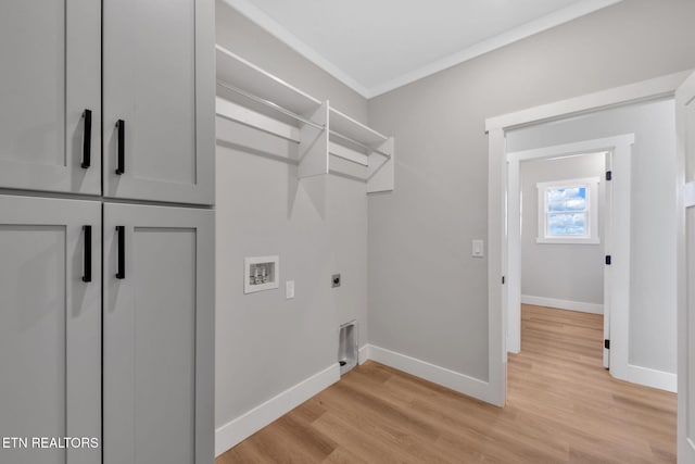 washroom featuring cabinets, washer hookup, ornamental molding, light hardwood / wood-style floors, and hookup for an electric dryer