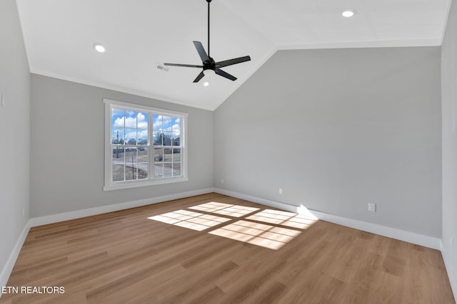 empty room with crown molding, vaulted ceiling, light hardwood / wood-style floors, and ceiling fan