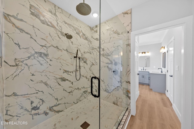 bathroom featuring hardwood / wood-style flooring, vanity, and walk in shower