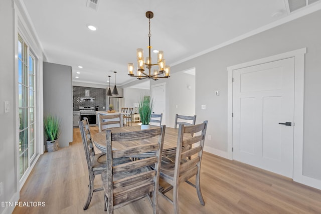 dining space with crown molding, light hardwood / wood-style floors, and a healthy amount of sunlight