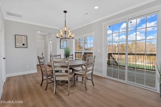 dining space featuring a notable chandelier, crown molding, and wood-type flooring