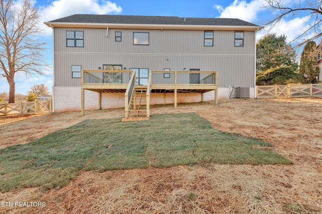 rear view of house with cooling unit, a yard, and a deck