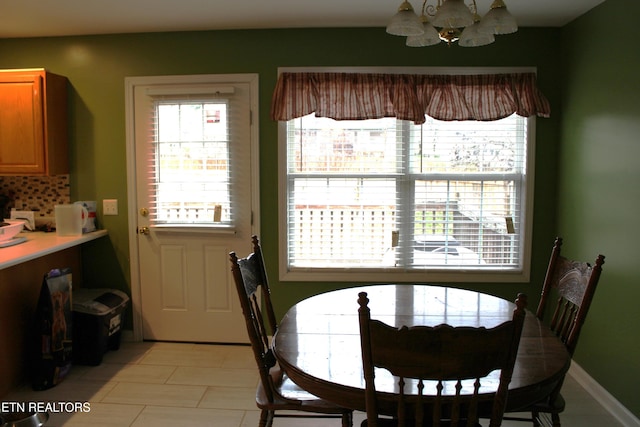 tiled dining area with a chandelier