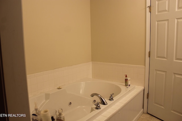 bathroom featuring tile patterned flooring and a relaxing tiled tub