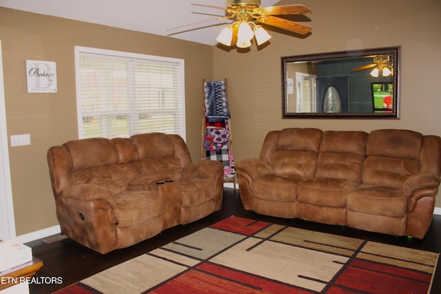 living room featuring ceiling fan and dark wood-type flooring