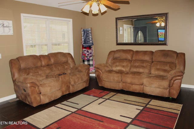 living room featuring ceiling fan and dark hardwood / wood-style floors