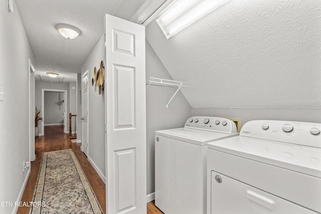 washroom with hardwood / wood-style flooring, washer and dryer, and a textured ceiling