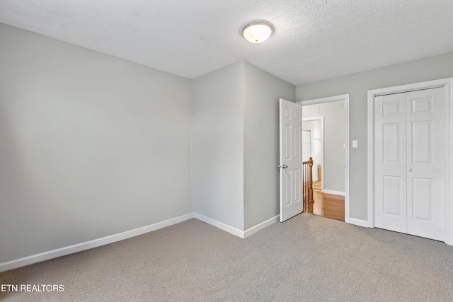 unfurnished bedroom with a textured ceiling and a closet