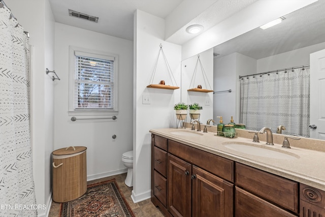 bathroom featuring vanity, curtained shower, and toilet