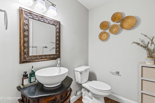 bathroom with vanity, toilet, and wood-type flooring