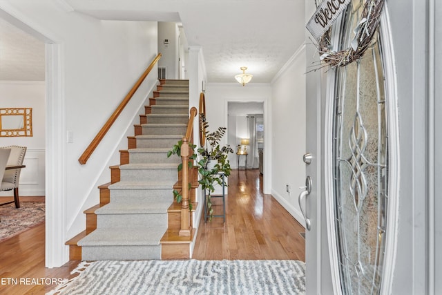 entrance foyer featuring wood-type flooring and ornamental molding