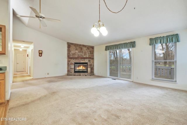 unfurnished living room featuring ceiling fan with notable chandelier, lofted ceiling, a fireplace, and light carpet