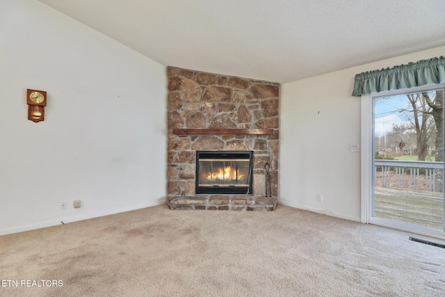 unfurnished living room featuring a stone fireplace, carpet, and lofted ceiling