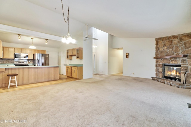 unfurnished living room featuring ceiling fan, a fireplace, light colored carpet, and lofted ceiling