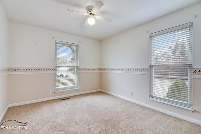 empty room featuring light carpet, plenty of natural light, and ceiling fan