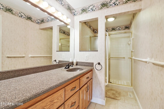 bathroom featuring tile patterned flooring, vanity, and a shower with shower door