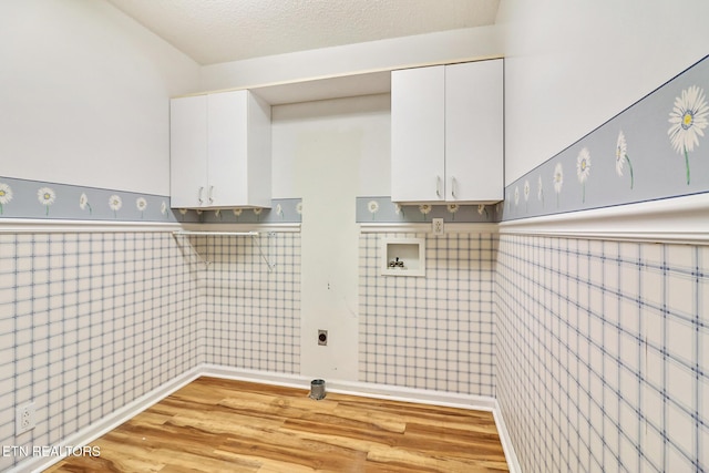 washroom featuring electric dryer hookup, cabinets, light wood-type flooring, and hookup for a washing machine