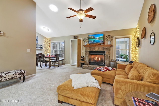 living room with high vaulted ceiling, light colored carpet, a stone fireplace, and ceiling fan