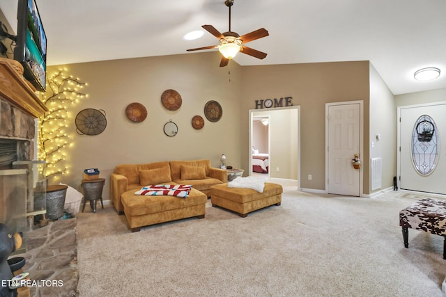 living room with carpet floors, high vaulted ceiling, a stone fireplace, and ceiling fan