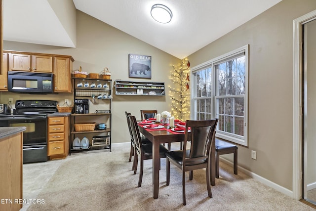 dining space featuring light carpet and lofted ceiling