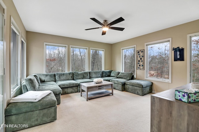 carpeted living room with ceiling fan