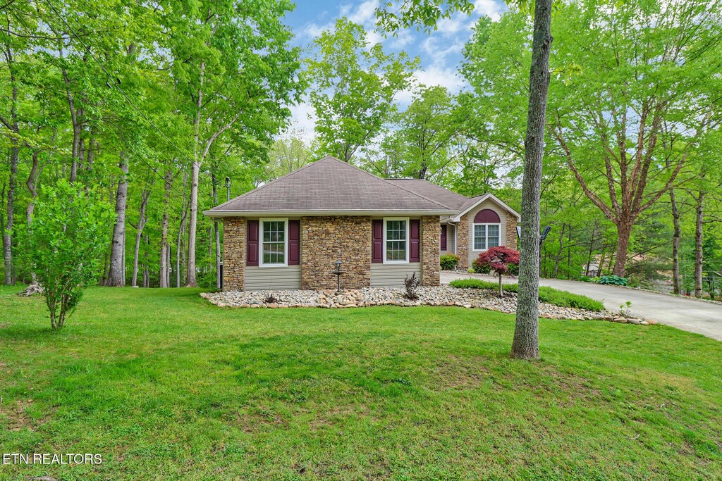 113 Burrough Ln, Fairfield Glade, TN 38558 - view of front of property with stone siding, a front lawn, and driveway
