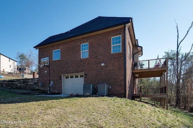 back of house featuring a yard, a garage, a balcony, and central air condition unit