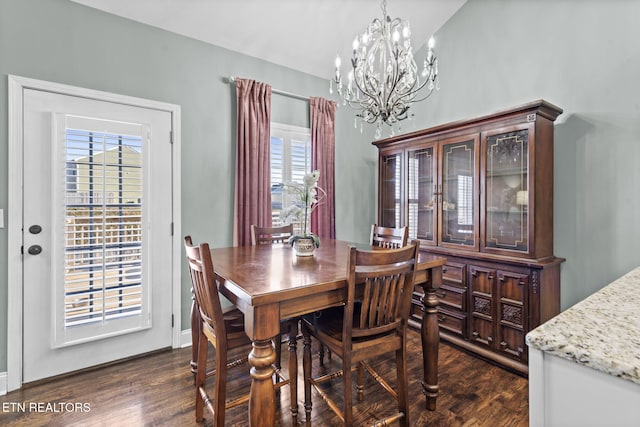 dining room featuring a chandelier, dark wood-type flooring, and vaulted ceiling