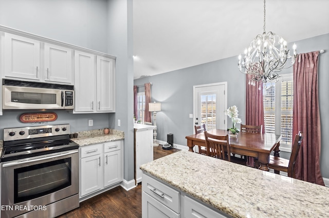 kitchen featuring a notable chandelier, decorative light fixtures, white cabinetry, and appliances with stainless steel finishes