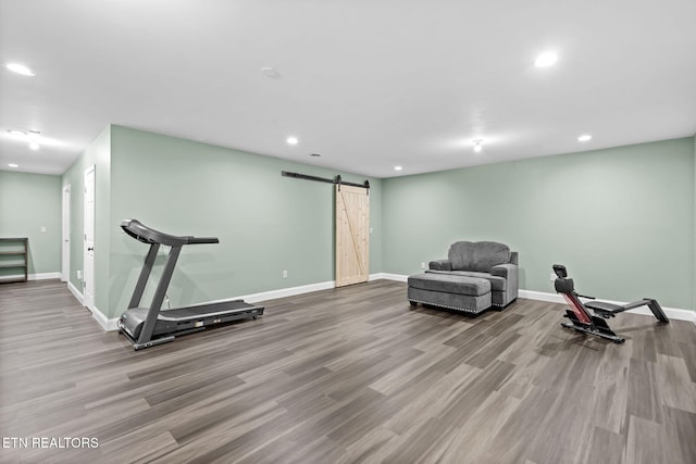 exercise area with a barn door and light wood-type flooring