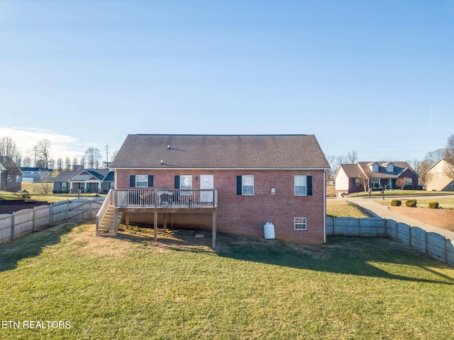 back of house featuring a lawn and a deck