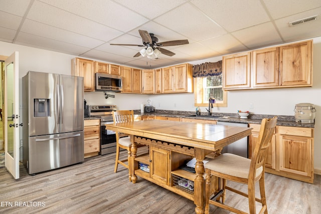 kitchen featuring a paneled ceiling, sink, stainless steel appliances, and light hardwood / wood-style flooring