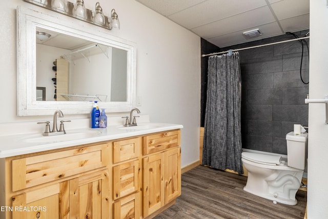 bathroom with a paneled ceiling, walk in shower, vanity, wood-type flooring, and toilet