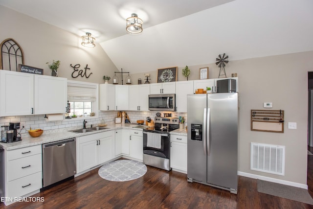 kitchen with white cabinetry, lofted ceiling, sink, and appliances with stainless steel finishes