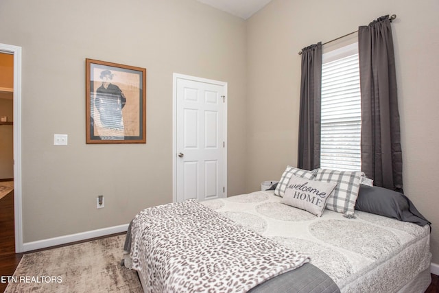 bedroom with wood-type flooring and multiple windows