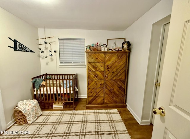 bedroom featuring hardwood / wood-style floors and a crib