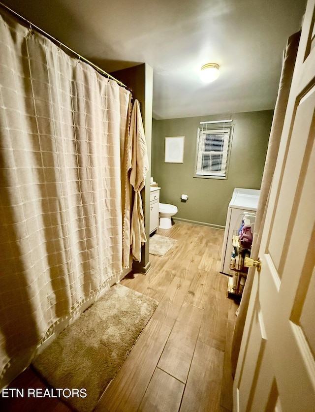 bathroom with wood-type flooring and toilet