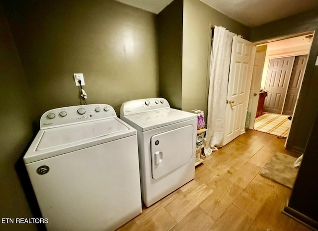 washroom featuring washer and clothes dryer and light hardwood / wood-style floors