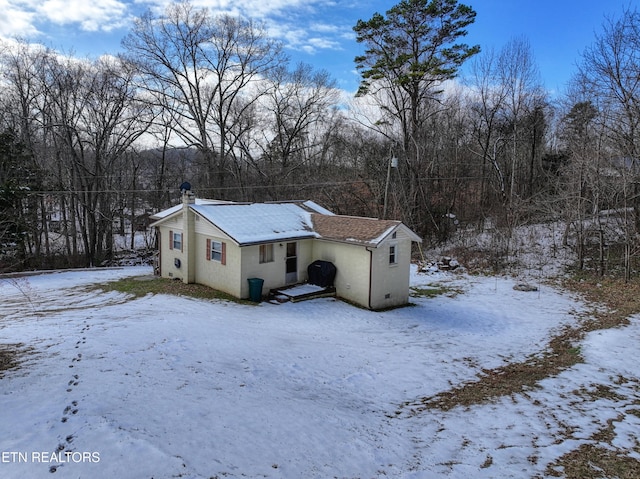 view of snow covered back of property