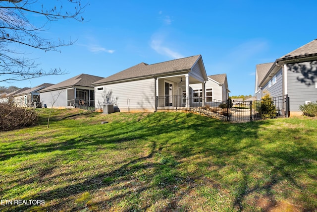 rear view of property featuring a yard and ceiling fan