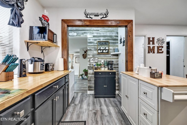 bar with butcher block countertops, white cabinets, and hardwood / wood-style floors