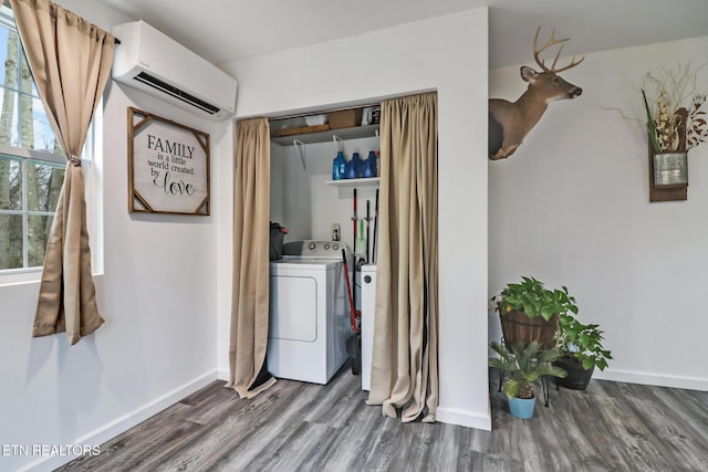 washroom featuring a wall unit AC, washer / clothes dryer, and wood-type flooring