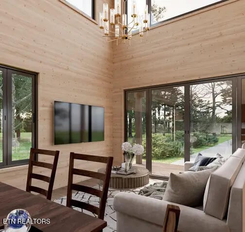 sunroom / solarium featuring french doors and an inviting chandelier