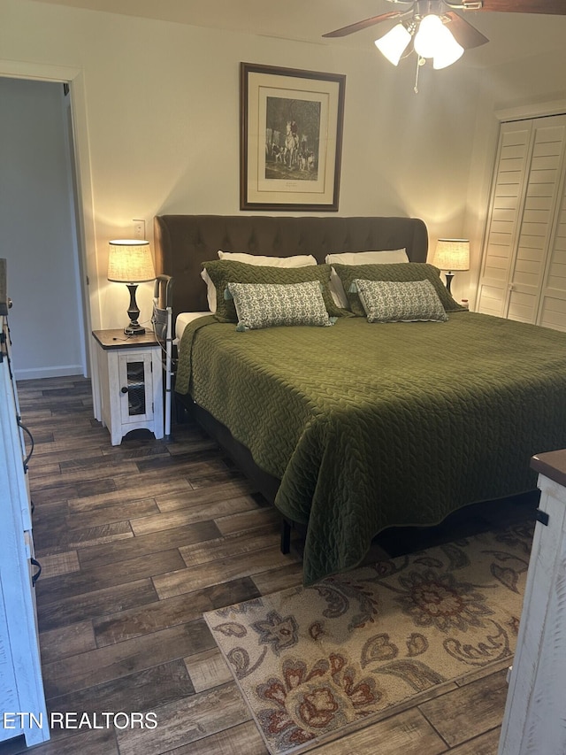 bedroom with dark wood-type flooring, ceiling fan, and a closet