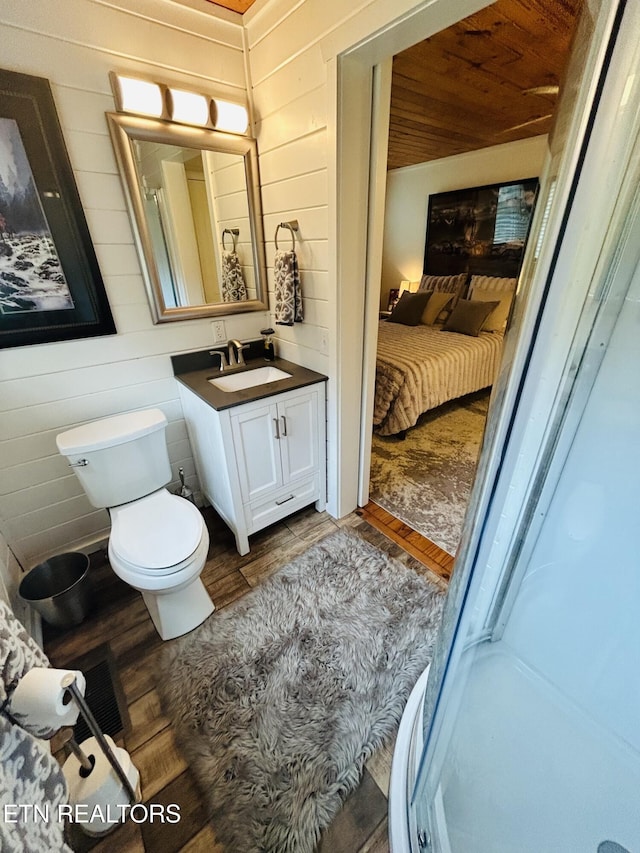 bathroom featuring wood walls, wood-type flooring, vanity, toilet, and wooden ceiling